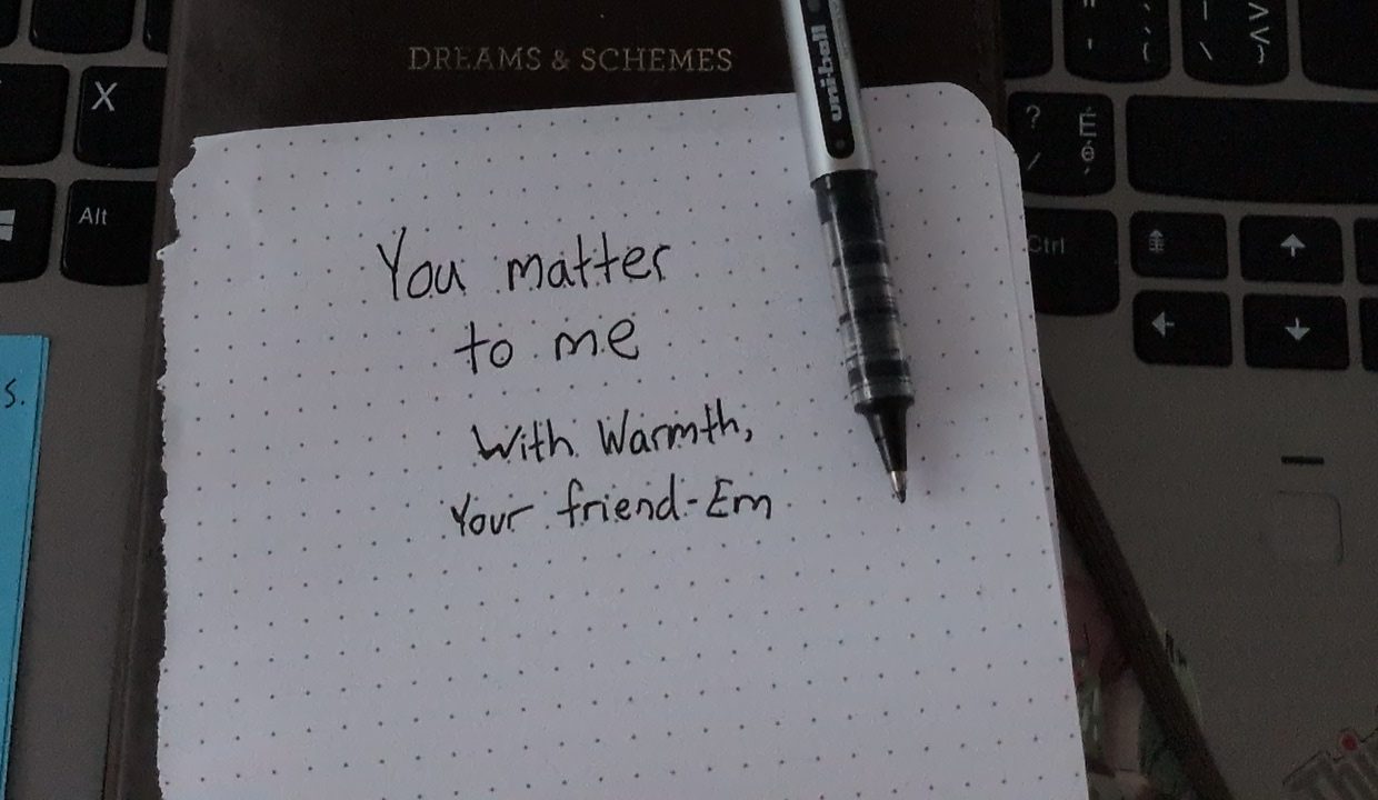 A handwritten note on a dotted notepad: "You matter to me. With warmth, your friend — Em."
